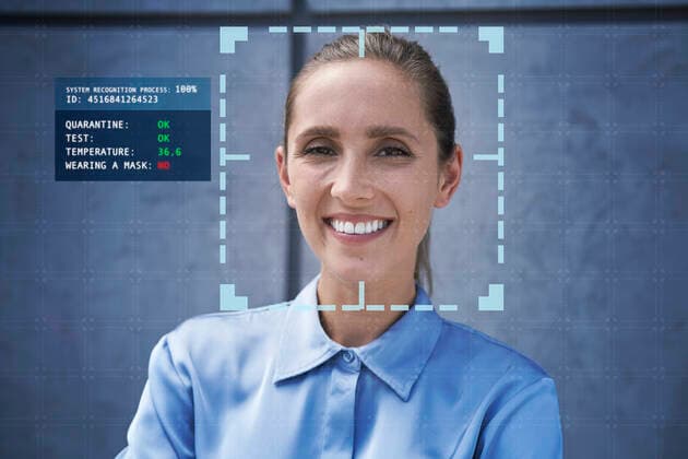 Smiling businesswoman with facial recognition technology in front of wall model released Symbolfoto property released ABIF01402