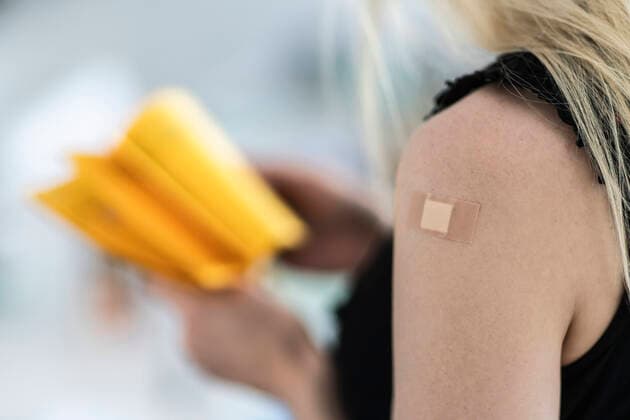 Woman with bandage on arm at vaccination center model released Symbolfoto property released CHPF00773