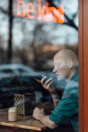 Businessman talking on mobile phone seen through cafe window model released Symbolfoto property released GUSF06112