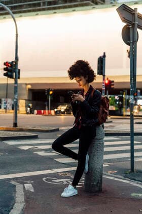 IMAGO Creative: 2021 Favoriten Young woman using mobile phone while leaning on bollard model released Symbolfoto MEUF03381