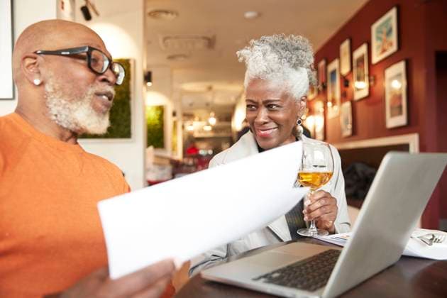 Senior businesswoman holding drink while looking at male colleague in restaurant model released Symbolfoto property released PMF02041