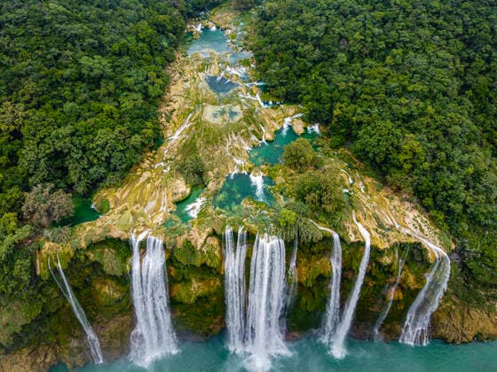 Aerial view of waterfall from rock formation amidst green trees, Huasteca Potosi, Mexico RUNF04607