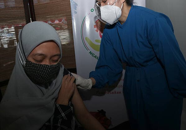 Virus Outbreak Indonesia A woman receives a dose of Sinovac vaccine during a mass vaccination for locals at OJK office in Malang City, East Java, Indonesia, on July 24, 2021. Indonesia is speeding its vaccination program as the number of COVID-19 days cases reach over 49.071 people. National cases reach over 3.082.410 since the beginning of the pandemic Malang Indonesia rochman-notitle210724_npTCp  Copyright: xAmanxRochmanx