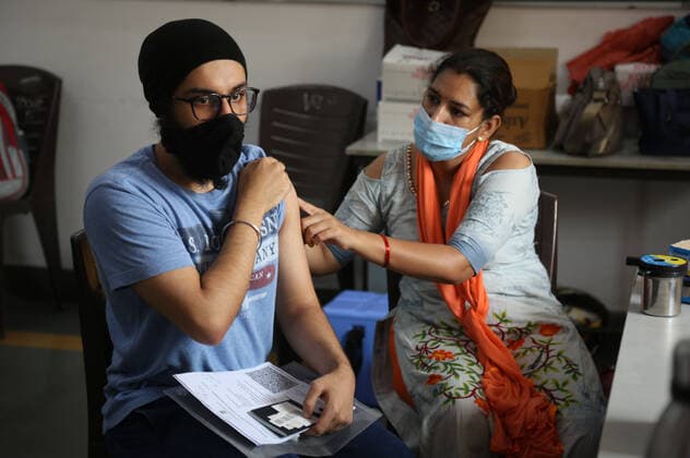 NEW DELHI, INDIA - JULY 23: A health worker administers a Covid-19 vaccine to a person at a vaccination centre on Mandir Marg, on July 23, 2021 in New Delhi, India. (Photo by Sanchit Khanna Hindustan Times) COVID-19 Vaccination Drive