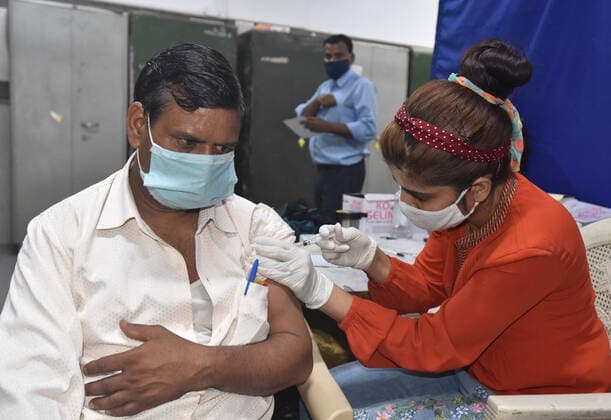 NEW DELHI, INDIA - JULY 23: A health worker administers a dose of Covid-19 vaccine to a beneficiary at SKV School, Mata Sundari Road DDU Marg, on July 23, 2021 in New Delhi, India. (Photo by Sonu Mehta Hindustan Times) COVID-19 Vaccination Drive