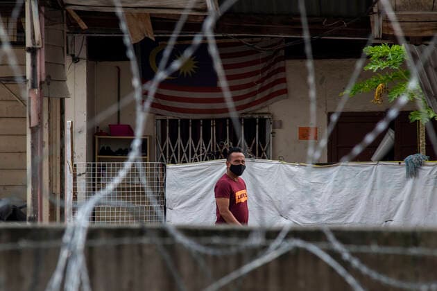 (210724) -- KUALA LUMPUR, July 24, 2021 -- A resident looks out from barbed wire in a community under the Enhanced Movement Control Order (EMCO) in Kuala Lumpur, Malaysia, July 24, 2021. Malaysia reported 15,902 new COVID-19 infections in the highest daily spike since the outbreak, bringing the national total to 996,393, the Health Ministry said Saturday. (Photo by Xinhua) MALAYSIA-COVID-19-CASES-NEW HIGH ChongxVoonxChung 