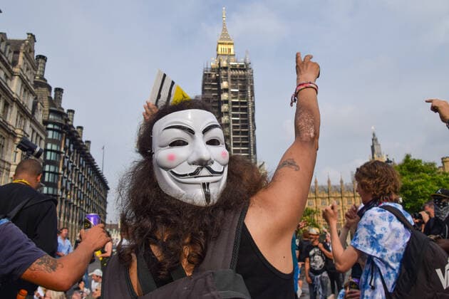July 24, 2021, London, United Kingdom: A protester wears a Guy Fawkes mask and gestures in Parliament Square during the demonstration..Thousands of protesters gathered in Westminster to protest against COVID-19 vaccinations, vaccine passports, and coronavirus restrictions, with many demonstrators calling the pandemic a hoax London United Kingdom - ZUMAs197 20210724_zaa_s197_211 Copyright: xVukxValcicx