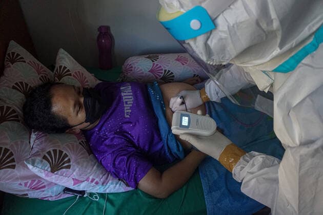 July 27, 2021, Badung, Bali, Indonesia: Health workers cheks a pregnant woman (bed right) on her quarantine room at Wisma Bima I, Kuta. Bali local government to centralized Covid-19 quarantines for asymptomatic and mild symptoms to make medical controlling easier. Before thousands of people die during self-quarantines in their own houses, based on Health Misitry data. Badung Indonesia - ZUMAb245 20210727_zip_b245_019 Copyright: xDickyxBisinglasix