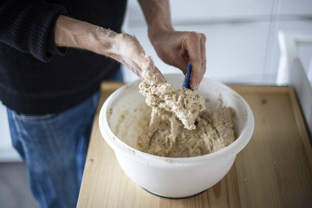 Symbolfoto zum Thema Brotbacken. Klebriger Teig wird mit einem Teigschaber von der Hand gestrichen. Berlin, 02.02.2021. Berlin Deutschland *** Bread baking symbol photo Sticky dough is scraped off the hand with a dough scraper Berlin, 02 02 2021 Berlin Germany Copyright: xJaninexSchmitz photothek.dex