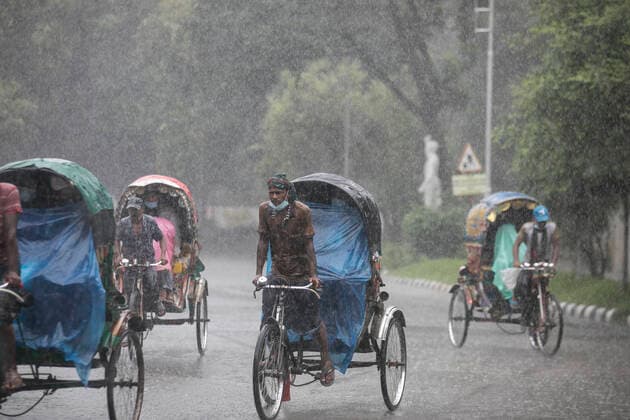 July 29, 2021, Dhaka, Bangladesh: Rickshaw pullers seen riding along the street during a rainy day amid the covid-19 lockdown..The country went into a strict lockdown and Heavy monsoon downpour caused extreme water logging in most areas of Dhaka city. Roads were submerged making travel slow and dangerous. Dhaka Bangladesh - ZUMAs197 20210729_zab_s197_013 Copyright: xSazzadxHossainx