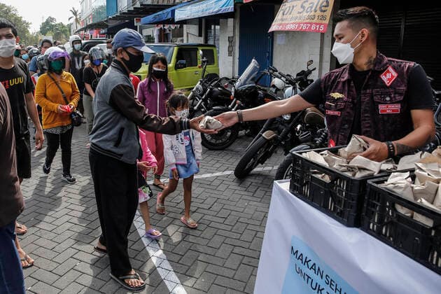 Free Food Distribution During Community Restriction Amid COVID-19 Pandemic Volunteer giving free food for citizens affected by COVID-19 pandemic restriction in Kuta, Bali, Indonesia on July 30 2021. Indonesian government imposes emergency community restriction to curb the surge of COVID-19 infections across the country until August 2nd 2021. Indonesia has become the new epicentre of COVID-19 with more than 2 million cases recorded and 80,000 deaths since the beginning of the pandemic. Kuta Bali Indonesia christo-voluntee210730_nplCN  Copyright: xJohanesxChristox