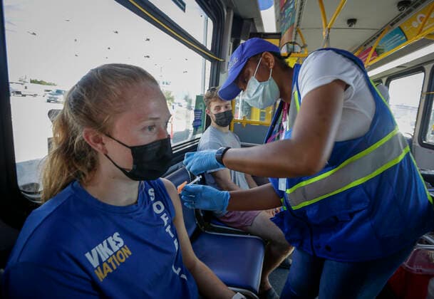 (210730) -- DELTA (CANADA), July 30, 2021 -- A woman receives the COVID-19 vaccine on a COVID-19 vaccine bus at Tsawwassen Ferry Terminal in Delta, British Columbia, Canada, on July 30, 2021. The vaccine bus is part of Vax for B.C. campaign in British Columbia aimed at boosting up the vaccination rate. (Photo by Xinhua) CANADA-DELTA-COVID-19-VACCINE BUS LiangxSen 