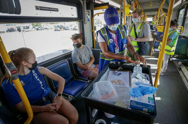 (210730) -- DELTA (CANADA), July 30, 2021 -- Healthcare workers are seen on a COVID-19 vaccine bus at Tsawwassen Ferry Terminal in Delta, British Columbia, Canada, on July 30, 2021. The vaccine bus is part of Vax for B.C. campaign in British Columbia aimed at boosting up the vaccination rate. (Photo by Xinhua) CANADA-DELTA-COVID-19-VACCINE BUS LiangxSen 