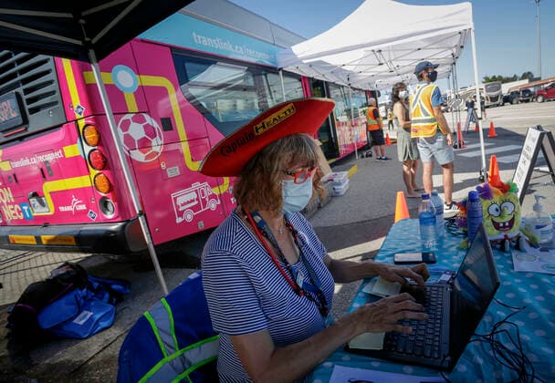 (210730) -- DELTA (CANADA), July 30, 2021 -- A healthcare worker is seen in front of a COVID-19 vaccine bus at Tsawwassen Ferry Terminal in Delta, British Columbia, Canada, on July 30, 2021. The vaccine bus is part of Vax for B.C. campaign in British Columbia aimed at boosting up the vaccination rate. (Photo by Xinhua) CANADA-DELTA-COVID-19-VACCINE BUS LiangxSen 