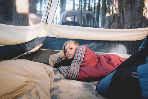 IMAGO Creative: Klimawandel - Umwelterziehung Sleepy Boy wrapped in Sleeping Bag Wakes up in the Woods Yuba Pass, CA, United States CR_CXBA210330A-682472-01 ,model released, Symbolfoto