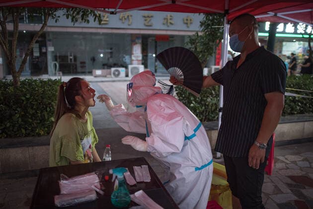 (210803) -- WUHAN, Aug. 3, 2021 -- Xu Yong (1st R) fans for medical worker Zhao Xiaoqing (C) as she takes a swab sample from a resident for COVID-19 nucleic acid testing in Wuhan, central China s Hubei Province, Aug. 3, 2021. Wuhan City, capital of central China s Hubei Province, launched another citywide COVID-19 nucleic acid testing campaign on Tuesday, according to a press conference held by the provincial COVID-19 prevention and control headquarters. Wuhan, once hard-hit by COVID-19, identified new local clusters of cases on Monday when seven migrant workers at the Wuhan Economic & Technological Development Zone tested positive for the coronavirus. ) CHINA-HUBEI-WUHAN-COVID-19-TESTING (CN) XiaoxYijiu