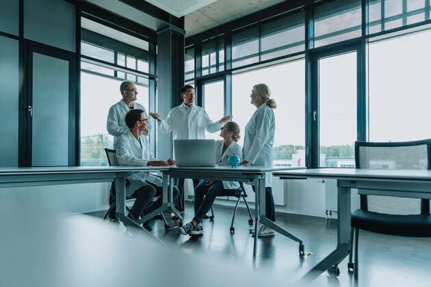 Doctors and scientists using laptop while having discussion at office model released Symbolfoto property released MFF06315