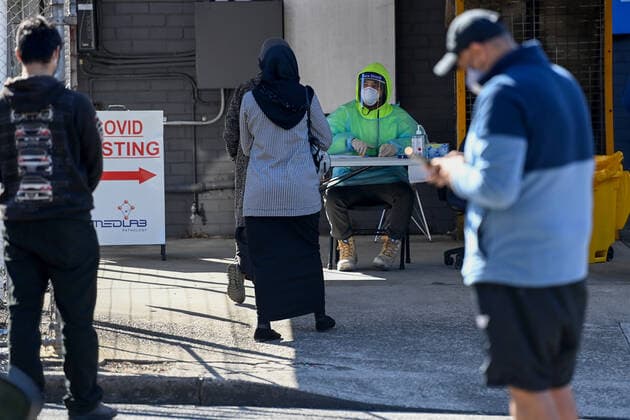 NSW CORONAVIRUS COVID19, A health worker dressed in Personal Protection Equipment (PPE) checks people in for their COVID-19 test at the Yagoona MedLab Pathology Walk-in clinic in Sydney, Saturday, August 7, 2021. Greater Sydney and surrounding regions are in lockdown until at least August 28 and the NSW Hunter will be locked down for a week as health authorities battle to contain an outbreak of the virulent Delta strain. ( NO ARCHIVING, EDITORIAL USE ONLY, NO USE IN BOOKS WITHOUT CONSENT SYDNEY NSW AUSTRALIA  Copyright: xBIANCAxDExMARCHIx 20210807001565067419
