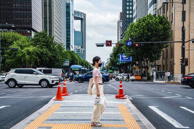 August 6, 2021, Seoul, South Korea: A woman wearing a facial mask as preventive measure against the spread of Covid-19 crosses the road in Seoul..South Korea is reporting 1,704 newly confirmed COVID19 cases in South Korea. Seoul South Korea - ZUMAs197 20210806_zaa_s197_230 Copyright: xSimonxShinx