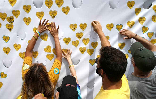NY Covid March To Remember, Across The Brooklyn Bridge In New York City Marchers place yellow hearts on a canvas after a walk across the Brooklyn Bridge in remembrance of those who lost their lives during the Covid-19 pandemic, on August 7, 2021 in New York City, USA. The Yellow Hearts movement was started by a family that wanted to share a symbol of remembrance for those lost during the lockdown. New York City NY United States lamparski-nycovidm210807_npwhT  Copyright: xJohnxLamparskix