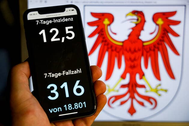 Coronavirus in Germany Covid 19 Dashboard of the Robert Koch Institute DEU, Germany, Brandenburg, 08 08 2021 The 7-day incidence for the state Cases last 7 days 100 000 PE is displayed on an iPhone, with the state coat of arms in the background.