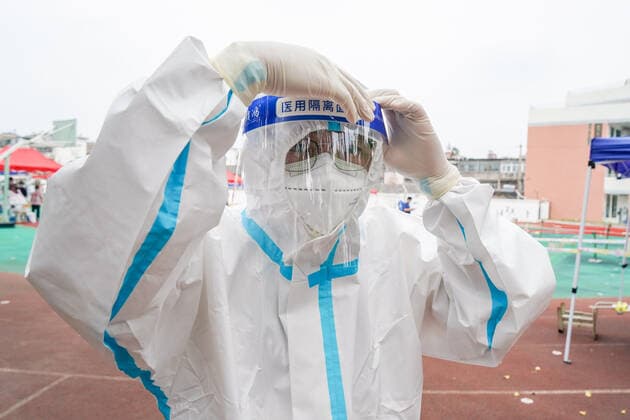 (210809) -- YANGZHOU, Aug. 9, 2021 -- A community service worker puts on a face shield at a COVID-19 nucleic acid testing site in Guangling District of Yangzhou, east China s Jiangsu Province, Aug. 9, 2021. The city of Yangzhou has launched its fifth round of COVID-19 mass testing on Monday. ) CHINA-JIANGSU-YANGZHOU-COVID-19-TESTS (CN) LixBo 