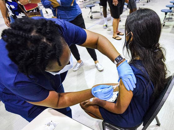 News Bilder des Tages August 9, 2021, Longwood, Florida, United States: A nurse gives 16-year-old to a girl a dose of the Pfizer vaccine at a COVID-19 vaccine clinic at Lyman High School in Longwood on the day before classes begin for the 2021-22 school year. .Seminole County Public Schools have implemented a face covering mask mandate for students for 30 days unless a parent chooses to opt out of the requirement. Longwood United States - ZUMAs197 20210809_zaa_s197_197 Copyright: xPaulxHennessyx