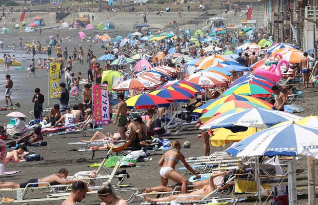 August 11, 2021, Fujisawa, Japan - Katase Enoshima beach is crowded with bathers and beach umbrellas amid outbreak of the new coronavirus in Fujisawa, suburban Tokyo on Wednesday, August 11, 2021.  (166936601)
