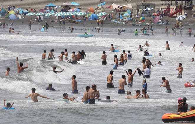 August 11, 2021, Fujisawa, Japan - Katase Enoshima beach is crowded with bathers and beach umbrellas amid outbreak of the new coronavirus in Fujisawa, suburban Tokyo on Wednesday, August 11, 2021.  (166936602)