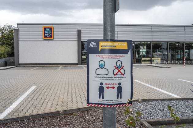 Gersthofen, Bavaria, Germany - 08 August 2021: Notes on compliance with FFP 2 mask requirement and compliance with minimum distance Covid 19 coronavirus protection measures in the parking lot of a German Aldi Süd grocery store