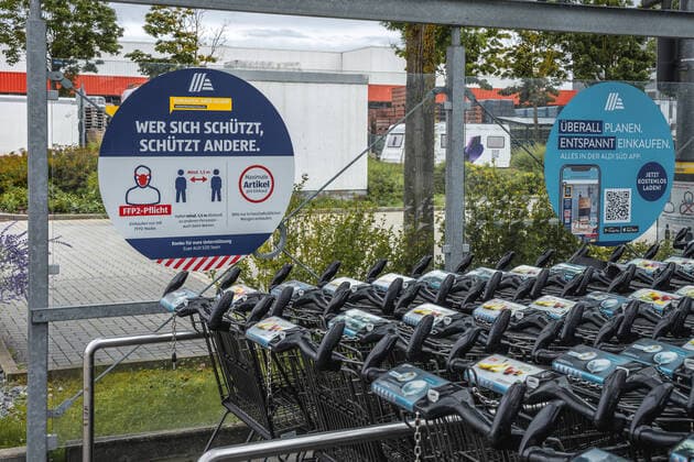 Gersthofen, Bavaria, Germany - 08 August 2021: Notes on compliance with FFP 2 mask requirement and compliance with minimum distance Covid 19 coronavirus protection measures in the parking lot of a German Aldi Süd grocery store