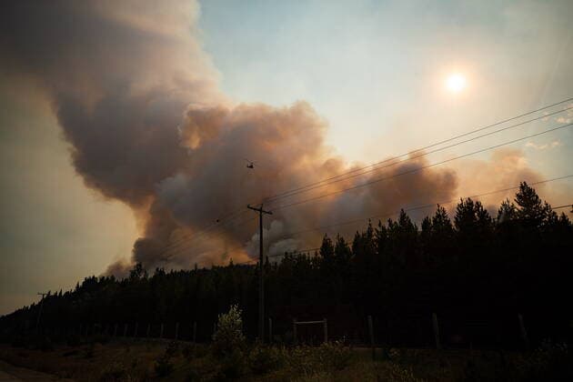 August 11, 2021, MERRITT, BC, Canada: A helicopter with a water bucket flies past smoke rising into the air while battling the July Mountain wildfire along the Coquihalla Highway south of Merritt, B.C., on Wednesday, August 11, 2021. MERRITT Canada  - ZUMAc35_ 20210811_zaf_c35_269 Copyright: xDarrylxDyckx