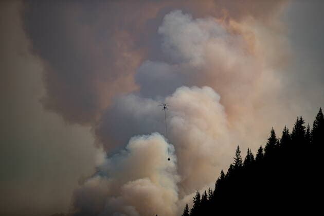 August 11, 2021, MERRITT, BC, Canada: A helicopter with a water bucket flies past smoke rising into the air while battling the July Mountain wildfire along the Coquihalla Highway south of Merritt, B.C., on Wednesday, August 11, 2021. MERRITT Canada  - ZUMAc35_ 20210811_zaf_c35_273 Copyright: xDarrylxDyckx