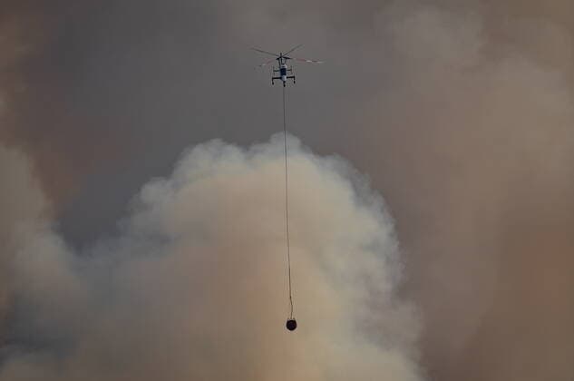 August 11, 2021, MERRITT, BC, Canada: A helicopter with a water bucket flies past smoke rising into the air while battling the July Mountain wildfire along the Coquihalla Highway south of Merritt, B.C., on Wednesday, August 11, 2021. MERRITT Canada  - ZUMAc35_ 20210811_zaf_c35_280 Copyright: xDarrylxDyckx