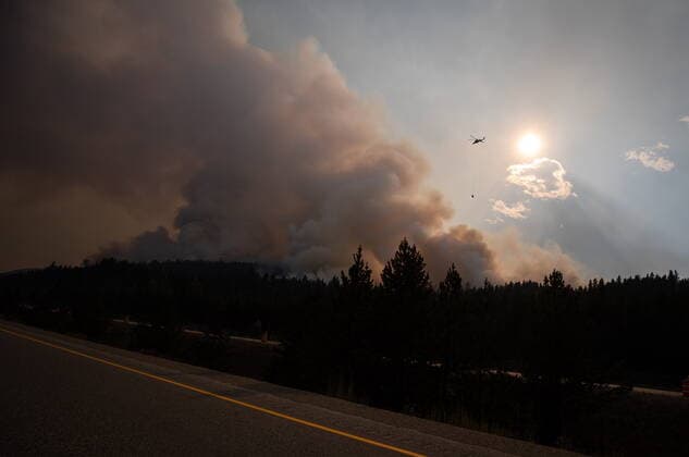 August 11, 2021, MERRITT, BC, Canada: A helicopter with a water bucket flies past smoke rising into the air while battling the July Mountain wildfire along the Coquihalla Highway south of Merritt, B.C., on Wednesday, August 11, 2021. MERRITT Canada  - ZUMAc35_ 20210811_zaf_c35_290 Copyright: xDarrylxDyckx