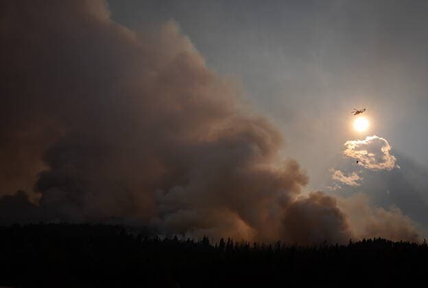 August 11, 2021, MERRITT, BC, Canada: A helicopter with a water bucket flies past smoke rising into the air while battling the July Mountain wildfire along the Coquihalla Highway south of Merritt, B.C., on Wednesday, August 11, 2021. MERRITT Canada  - ZUMAc35_ 20210811_zaf_c35_291 Copyright: xDarrylxDyckx