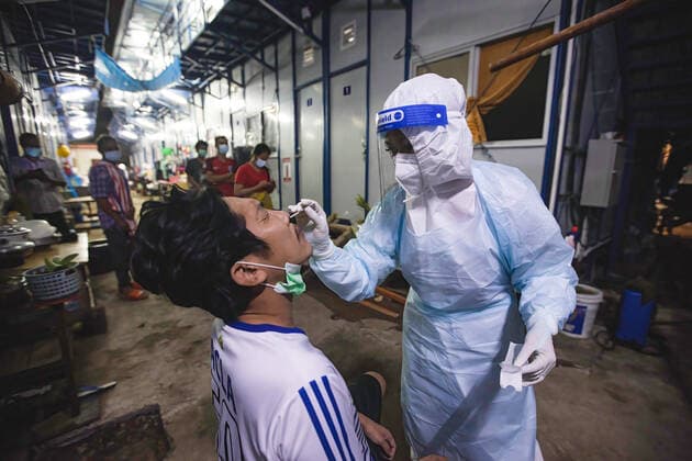 August 12, 2021, Bangkok, Thailand: Zendai volunteer staff wearing a Personal Protective Equipment ( PPE) suit takes a nasal swab from a worker at construction workers camp in Laksi..Covid-19 check-up in construction workers camp in Bangkok. Bangkok Thailand - ZUMAs197 20210812_zaa_s197_059 Copyright: xVaruthxPongsapipattx
