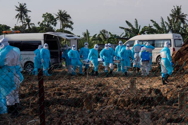 (210813) -- KUALA LUMPUR, Aug. 13, 2021 -- Workers wearing protective suits carry the body of a COVID-19 victim at a graveyard in Selangor, Malaysia, Aug. 13, 2021. Malaysia recorded 21,468 new COVID-19 infections, the Health Ministry said on Friday, bringing the national total to 1,363,683. (Photo by Xinhua) MALAYSIA-COVID-19-CASES ChongxVoonxChung