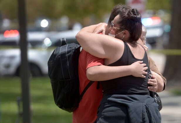 August 13, 2021, Albuquerque, New Mexico, USA: A family member hugs a student after a fatal shooting at Washington Middle School in Albuquerque on Friday. A student was shot and killed by another student. Albuquerque USA - ZUMAab1_ 20210813_zaf_ab1_007 Copyright: xRobertxBrowmanx