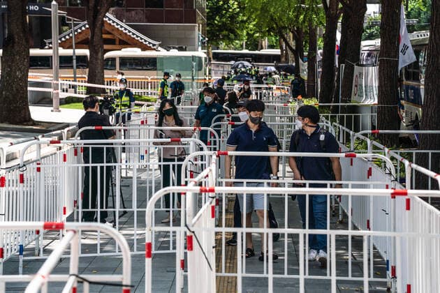 August 15, 2021, Seoul, South Korea: People wearing face masks walk along fences set up by police officers in Seoul..South Korean police sets up bus walls and checkpoints to block the protestors in Seoul. South Korea has banned protests ahead of the National Liberation Day, bewaring of revival of coronavirus outbreak caused by an anti-government rally last August. Seoul South Korea - ZUMAs197 20210815_zaa_s197_006 Copyright: xSimonxShinx