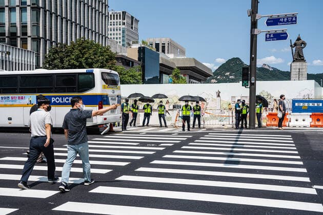 August 15, 2021, Seoul, South Korea: People wearing face masks cross the road in Seoul..South Korean police sets up bus walls and checkpoints to block the protestors in Seoul. South Korea has banned protests ahead of the National Liberation Day, bewaring of revival of coronavirus outbreak caused by an anti-government rally last August. Seoul South Korea - ZUMAs197 20210815_zaa_s197_014 Copyright: xSimonxShinx