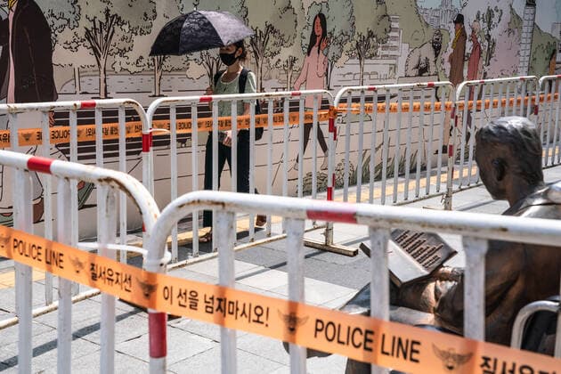 August 15, 2021, Seoul, South Korea: A woman wearing a face mask walks along fences set up by police in Seoul..South Korean police sets up bus walls and checkpoints to block the protestors in Seoul. South Korea has banned protests ahead of the National Liberation Day, bewaring of revival of coronavirus outbreak caused by an anti-government rally last August. Seoul South Korea - ZUMAs197 20210815_zaa_s197_017 Copyright: xSimonxShinx