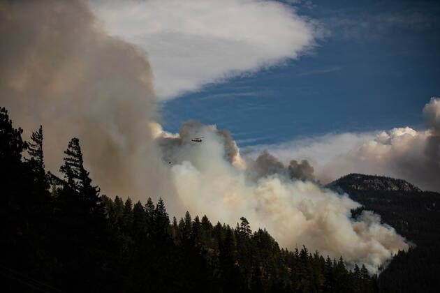 August 15, 2021, LYTTON, BC, CANADA: A helicopter carrying a water bucket flies past the Lytton Creek wildfire burning in the mountains near Lytton, B.C., on Sunday, August 15, 2021. LYTTON CANADA  - ZUMAc35_ 20210815_zaf_c35_079 Copyright: xDarrylxDyckx