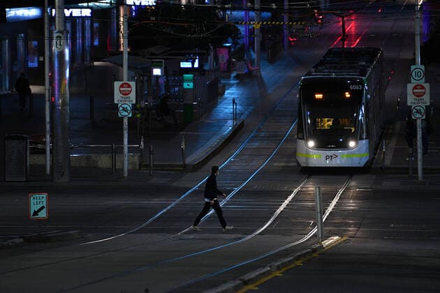 VICTORIA CORONAVIRUS COVID19, A person wearing a face mask is seen crossing a street ahead of the curfew in Melbourne, Monday, August 16, 2021. Victorian Premier Daniel Andrews today announced a night curfew which came into effect at 11.59pm on Monday. ( NO ARCHIVING, EDITORIAL USE ONLY, NO USE IN BOOKS WITHOUT CONSENT MELBOURNE VIC AUSTRALIA  Copyright: xJAMESxROSSx 20210816001567368775