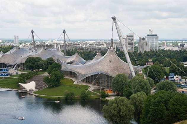 Architektur von Frei Otto 23.06.2019, Muenchen, Bayern, Deutschland, Europa - Blick vom Aussichtspunkt Olympiaberg auf die Olympia-Schwimmhalle und den Olympiasee im Olympiapark mit dem Olympiadorf im Hintergrund. *** 23 06 2019, Munich, Bavaria, Germany, Europe View from the vantage point Olympiaberg to the Olympia swimming hall and the Olympiasee in the Olympiapark with the Olympiadorf in the background.