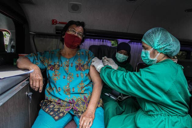 Coronavirus Vaccination In Indonesia A health worker injects the sinovac vaccine during a door-to-door Covid-19 vaccination program in Medan on August 19, 2021, Indonesia. The door-to-door Covid-19 vaccination program is a health service as officers go directly to the village or house of the community to be vaccinated. Medan Indonesia damanik-notitle210819_npP2g  Copyright: xIvanxDamanikx