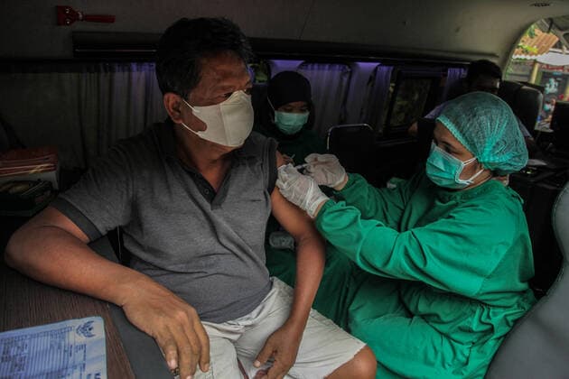 Coronavirus Vaccination In Indonesia A health worker injects the sinovac vaccine during a door-to-door Covid-19 vaccination program in Medan on August 19, 2021, Indonesia. The door-to-door Covid-19 vaccination program is a health service as officers go directly to the village or house of the community to be vaccinated. Medan Indonesia damanik-notitle210819_npbXw  Copyright: xIvanxDamanikx