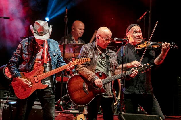 Fritz Puppel guitar , Roger Heinrich drums , Toni Krahl vocals, guitar and Georgi Gogow violin L R from the group CITY founded in 1972 in East Berlin GDR during the Candelight Open Air rock concert live in Coswig
