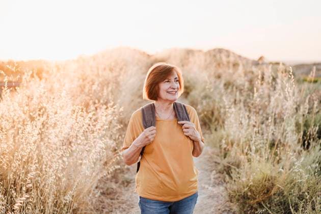 Smiling senior woman looking away while hiking model released Symbolfoto EBBF04431