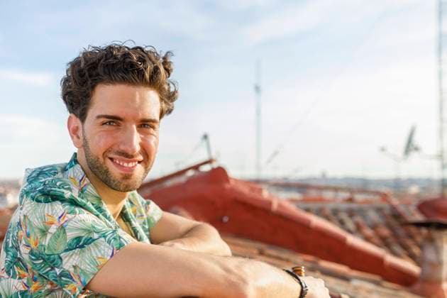 IMAGO Creative, Jahreszeit Sommer, Sommer in der Stadt Smiling young man on terrace during weekend model released Symbolfoto property released IFRF00991